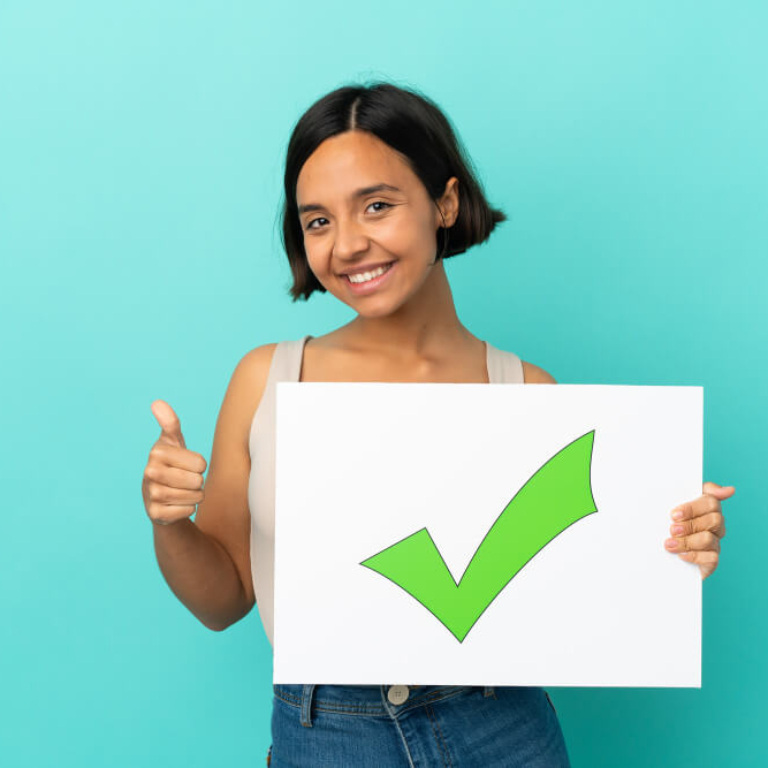 young-mixed-race-woman-isolated-blue-background-holding-placard-with-text-green-check-mark-icon-with-thumb-up (1)